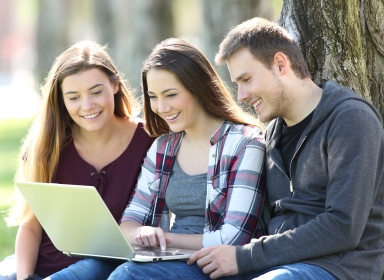 3 personer, der kigger på en computer 