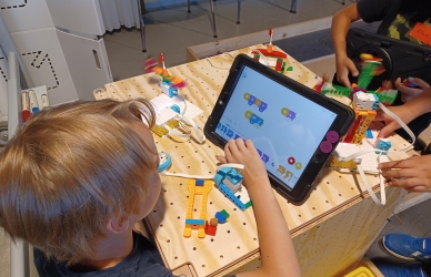 Barn, der sidder og spiller på ipad