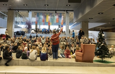 Billede af en kvinde, der på en scenen foran en masse mennesker